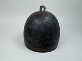a black bell that is sitting on a white surface