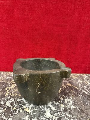 un bol en marbre sur une table en marbre, avec un fond rouge