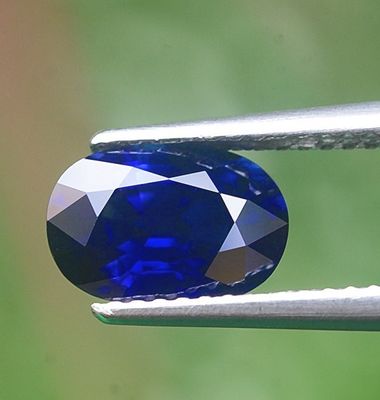 un gros plan d'un diamant bleu tenu par une pince