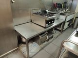 une grande cuisine en inox équipée d'une cuisinière et d'un évier