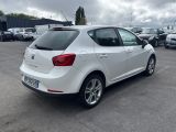 the rear end of a white car parked in a parking lot