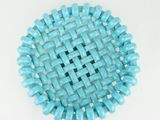 a close up of a blue beaded object on a white surface