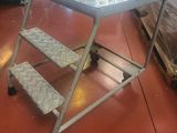 a metal table with two steps on it in a room