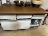 une cuisine équipée d'une cuisinière, d'un four et d'un saladier posé sur le plan de travail