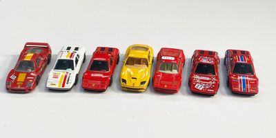 plusieurs petites voitures sont alignées sur une surface blanche