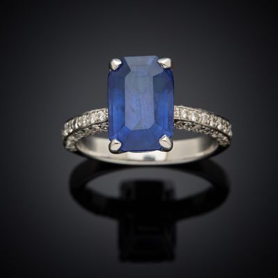 a blue sapphire and diamond ring on a black surface