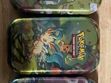 Six boîtes Pokémon sont alignées sur une surface en bois