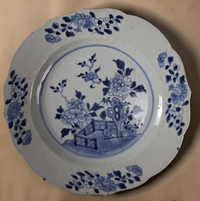 une assiette bleue et blanche sur laquelle est représentée une maison