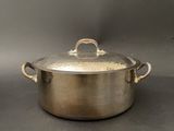 a large metal pot with a handle on a table