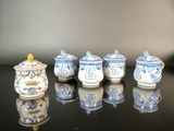 several blue and white teapots are lined up on a black table