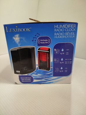 emballage d'un radio-réveil noir et rouge posé sur une table blanche