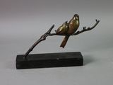 statue of a bird perched on a branch on a marble base