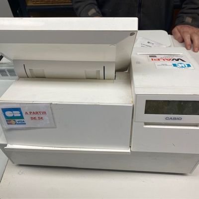 un homme debout à côté d'une machine posée sur une table