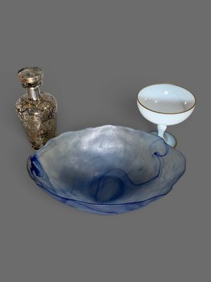 un bol bleu et un vase argenté posés sur une table
