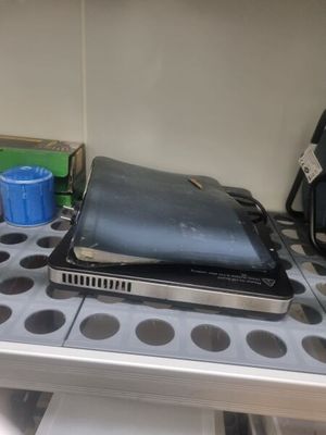un ordinateur portable posé sur une étagère dans une cuisine