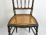 une chaise ancienne en bois avec une assise en osier, sur fond blanc