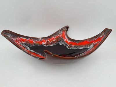 une image représentant un saladier en verre rouge et noir posé sur une surface blanche