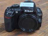 a camera sitting on a wooden table with a card attached to it
