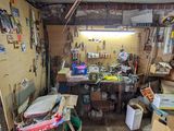une photo d'un garage encombré d'objets et d'outils