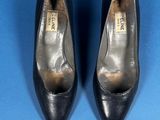 pair of black leather shoes on a blue background