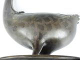 a metal bird that is sitting on top of a bowl