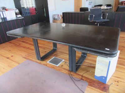 a black table with a laptop on it in an office