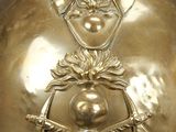 a gold bell with a face on it on a table