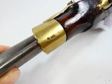 a hand that is holding a gun that is on a table
