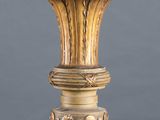 a gold vase on a pedestal on a gray background
