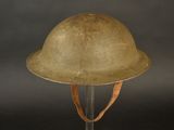 an old military helmet on a stand against a black background