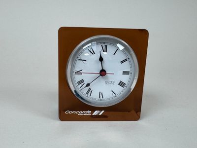 a small clock with roman numerals on it