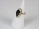 a close up of a silver ring with a black stone