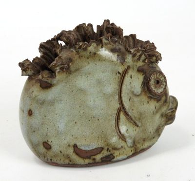 a small ceramic fish shaped object on a white surface