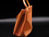 a brown handbag sitting on top of a black surface
