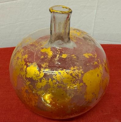 a yellow and brown vase sitting on a red cloth