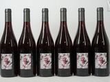 six bouteilles de vin sont alignées sur une table