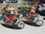 three figurines of people riding motorcycles in a display case
