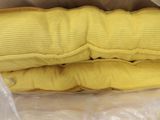 two yellow pillows in a plastic bag on a table