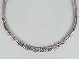 a close up of a silver necklace on a white surface
