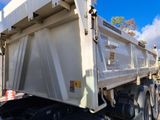 a white dump truck that is parked on the side of the road