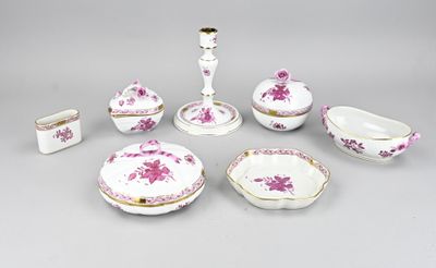 Plusieurs pièces de porcelaine rose et blanche sont disposées sur une surface grise