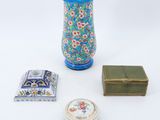a vase, a box, and a small box on a white surface