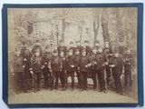 une vieille photo montrant un groupe d'hommes en uniforme posant pour une photo