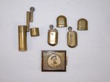 un assortiment d'objets en laiton, comprenant notamment un briquet, un étui à briquet et un briquet