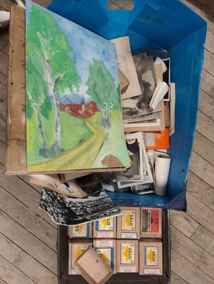 a painting in a box on the floor next to a box of stamps