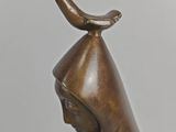 bronze statue of a woman with a bird on her head