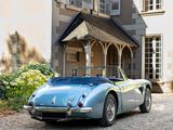 a blue sports car parked in front of a large house