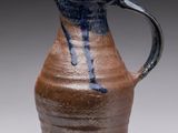 a brown and blue vase with a bird on it