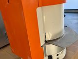 an orange and white coffee maker on a wooden table
