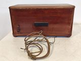 a small wooden box with a cord on it